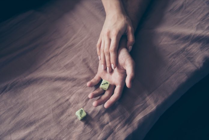 Love story concept. Couple playing dice with kamasutra pose throwing dice in a fit of passion