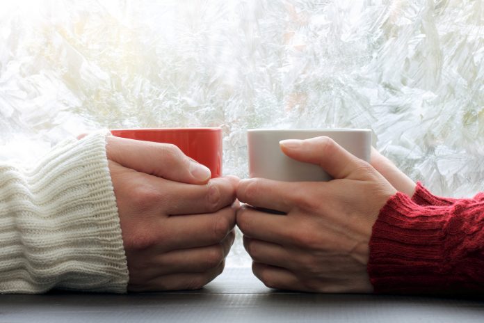 share warmest feelings/ warming meeting couple in love pair on a background of frozen window with a winter pattern