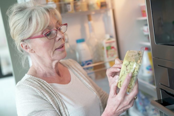 Senior woman checking expiration date on food product