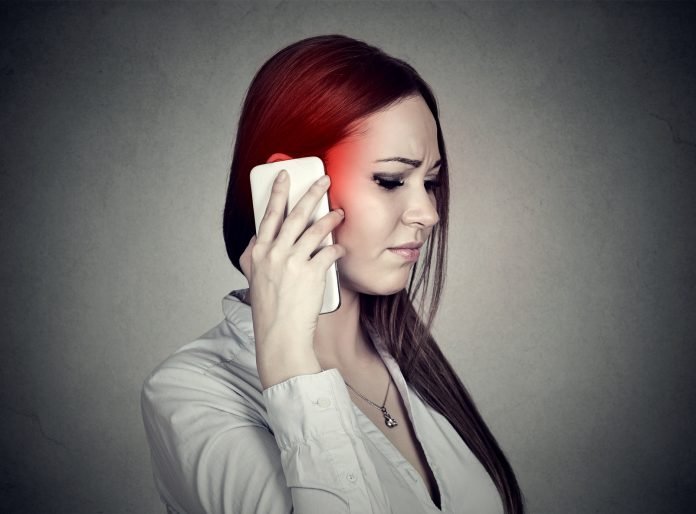 Upset sad woman talking on mobile phone. Cellular mobile radiation