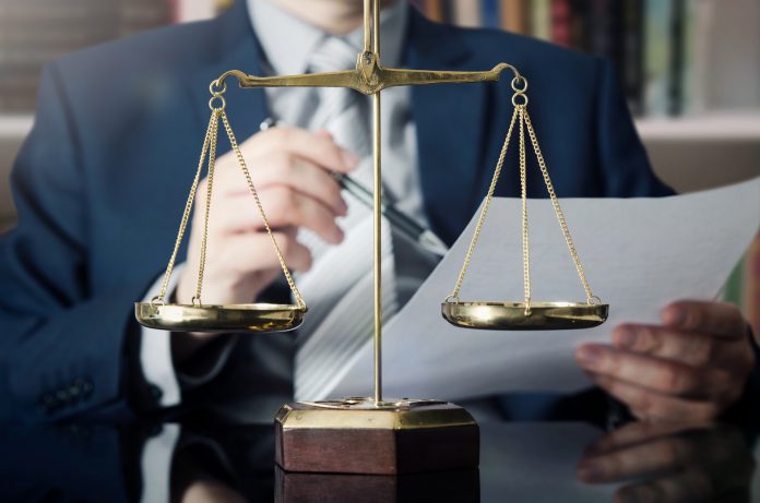 Weight scale of justice, lawyer in background
