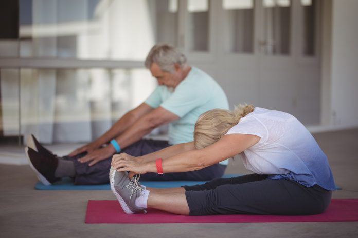 Senior couple performing stretching exercise