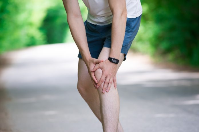 Pain in knee, joint inflammation, massage of male leg, injury while running, trauma during workout