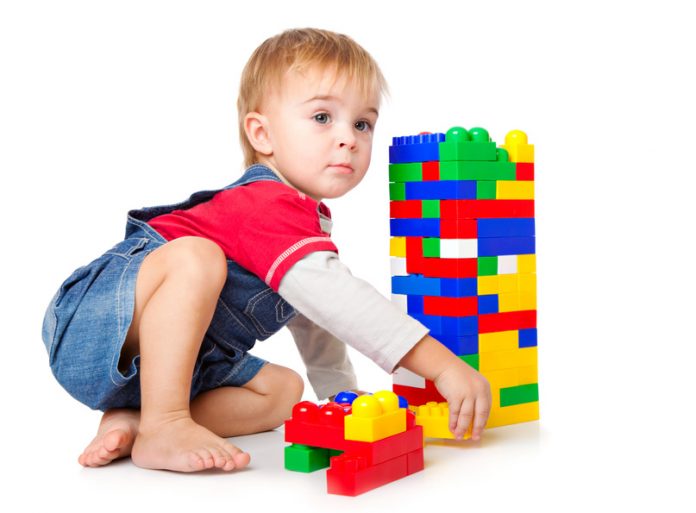 a funny boy is playing with lego