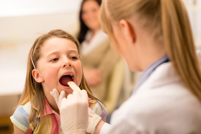 Pediatrician examine girl throat tongue