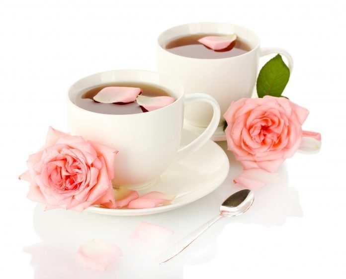 cups of tea with roses isolated on white