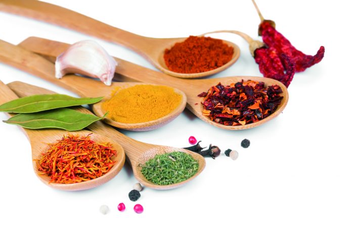 Colorful spices in wooden spoons