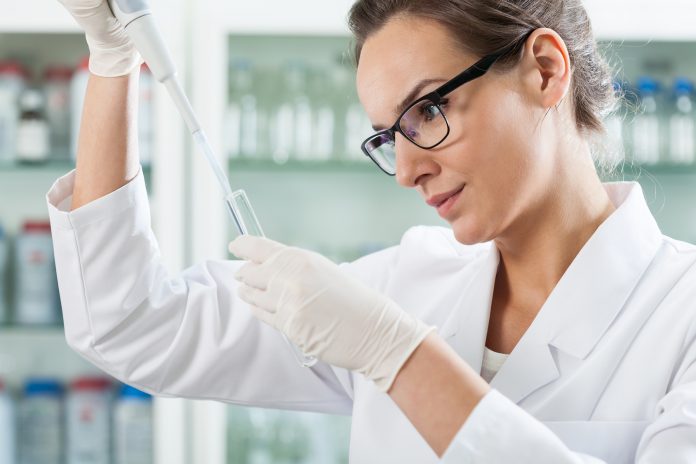 Scientist using pipette in laboratory