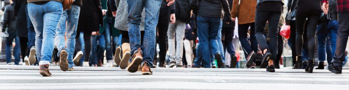 crowds of people in motion blur crossing a city street