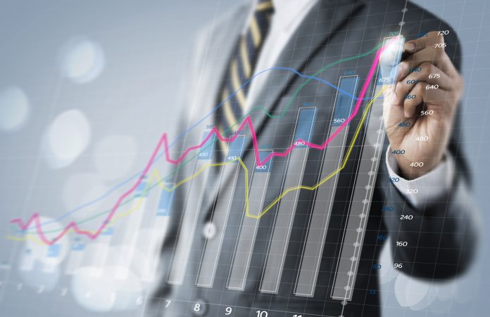 Business growth, progress or success concept. Businessman is drawing a growing 3d virtual hologram graph on bright tone background.