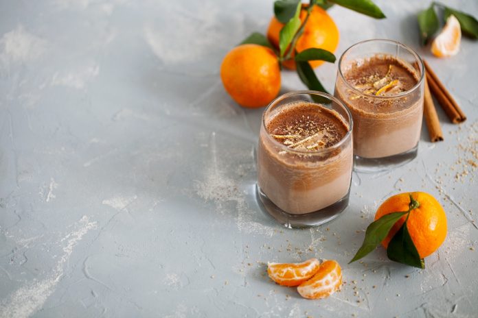 Glass of hot cocoa and tangerine orange zest