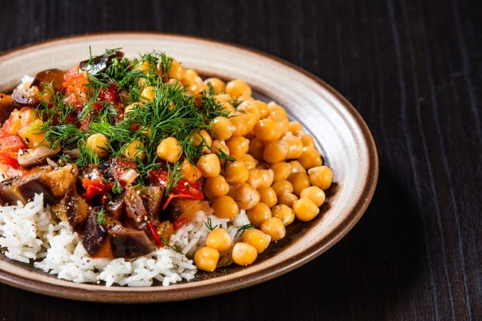 Rice with chickpea and vegetables on wooden table