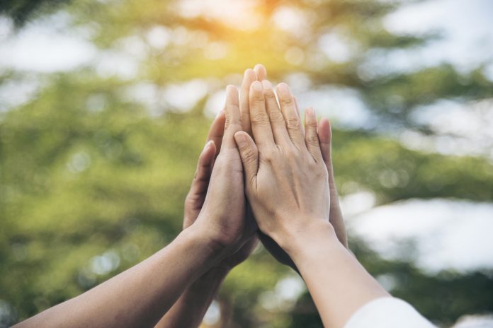 Teamwork high five as team together hands air greeting power tag team. Group of diversity people multiethnic