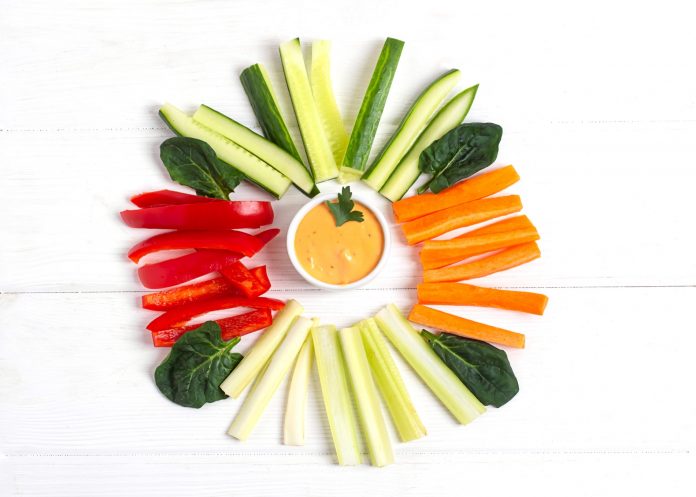 Diet raw sticks of celery,carrots,cucumber and red bell paper on a white wooden backgraund.copy space, top view