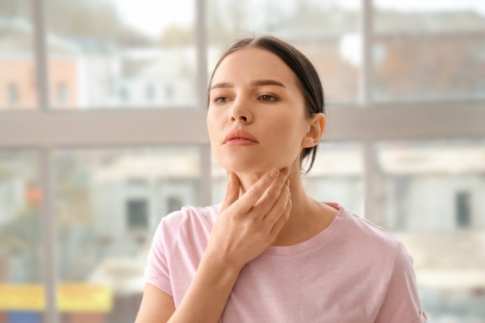 Young woman with thyroid gland problem at home