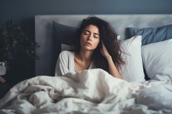 person with a headache and trouble sleeping at home