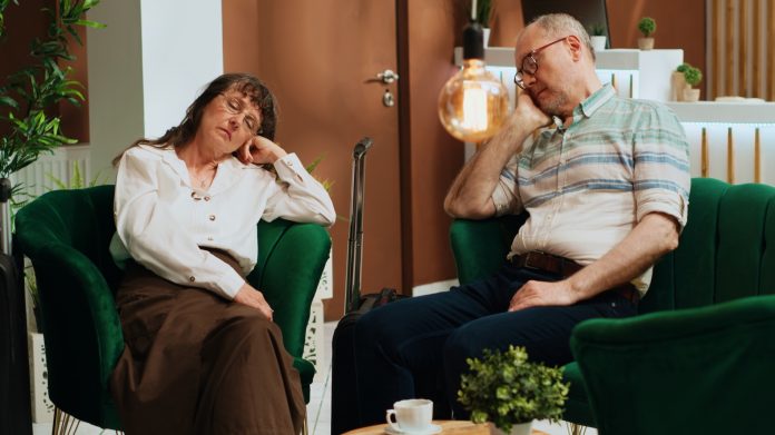 Tired old people falling asleep on sofa