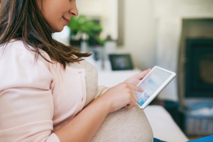 Scroll, relax and pregnant woman on sofa with tablet for online chat, typing and telehealth website. Smile, technology and mom on couch with digital app for growth, development or pregnancy support