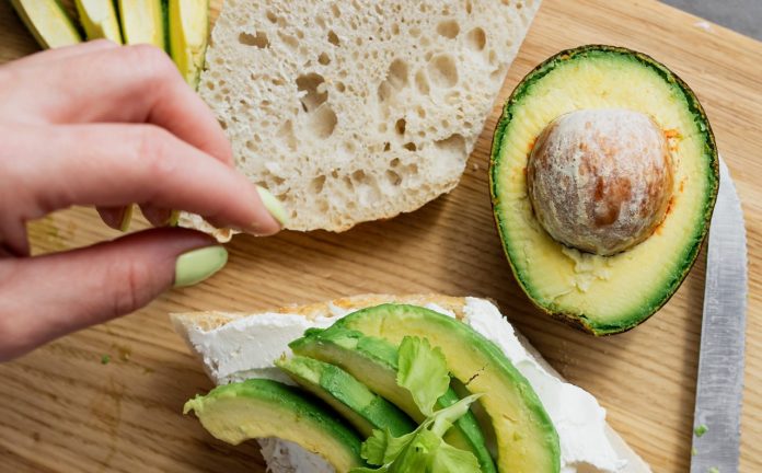 Woman making a healthy avocado toast