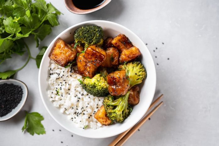 Healthy tofu bowl with broccoli and rice on white