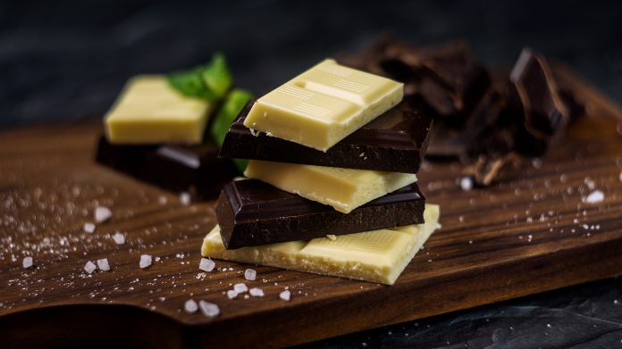 black and white chocolate on dark wooden background