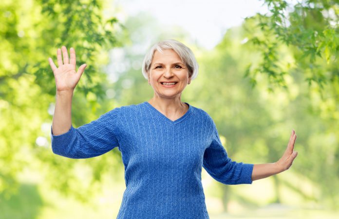 smiling senior woman touching something imaginary