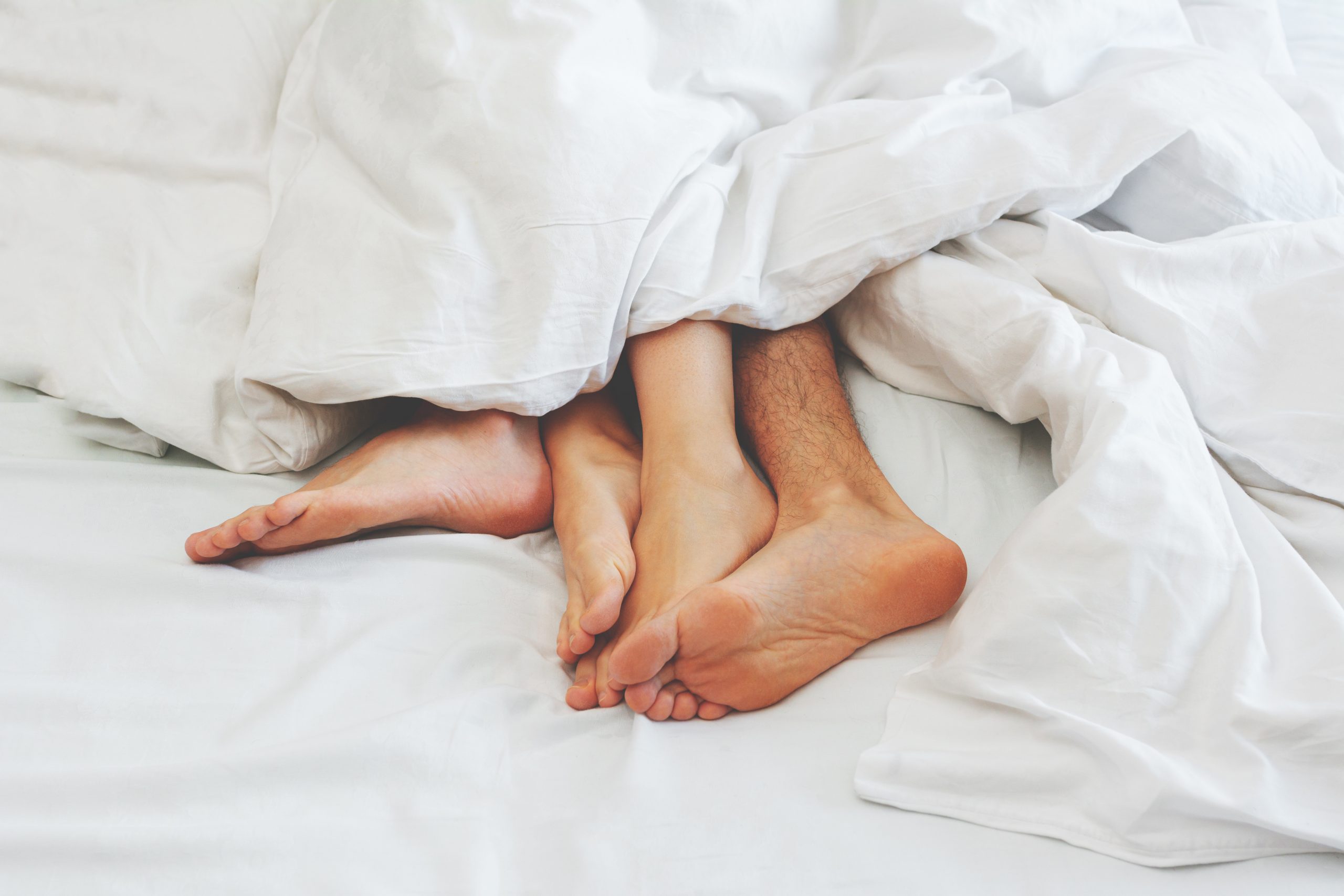 ноги на кровати под одеялом. согреть ноги. мужчина в постели под одеялом. как согреть ноги под одеялом. ноги в тепле.